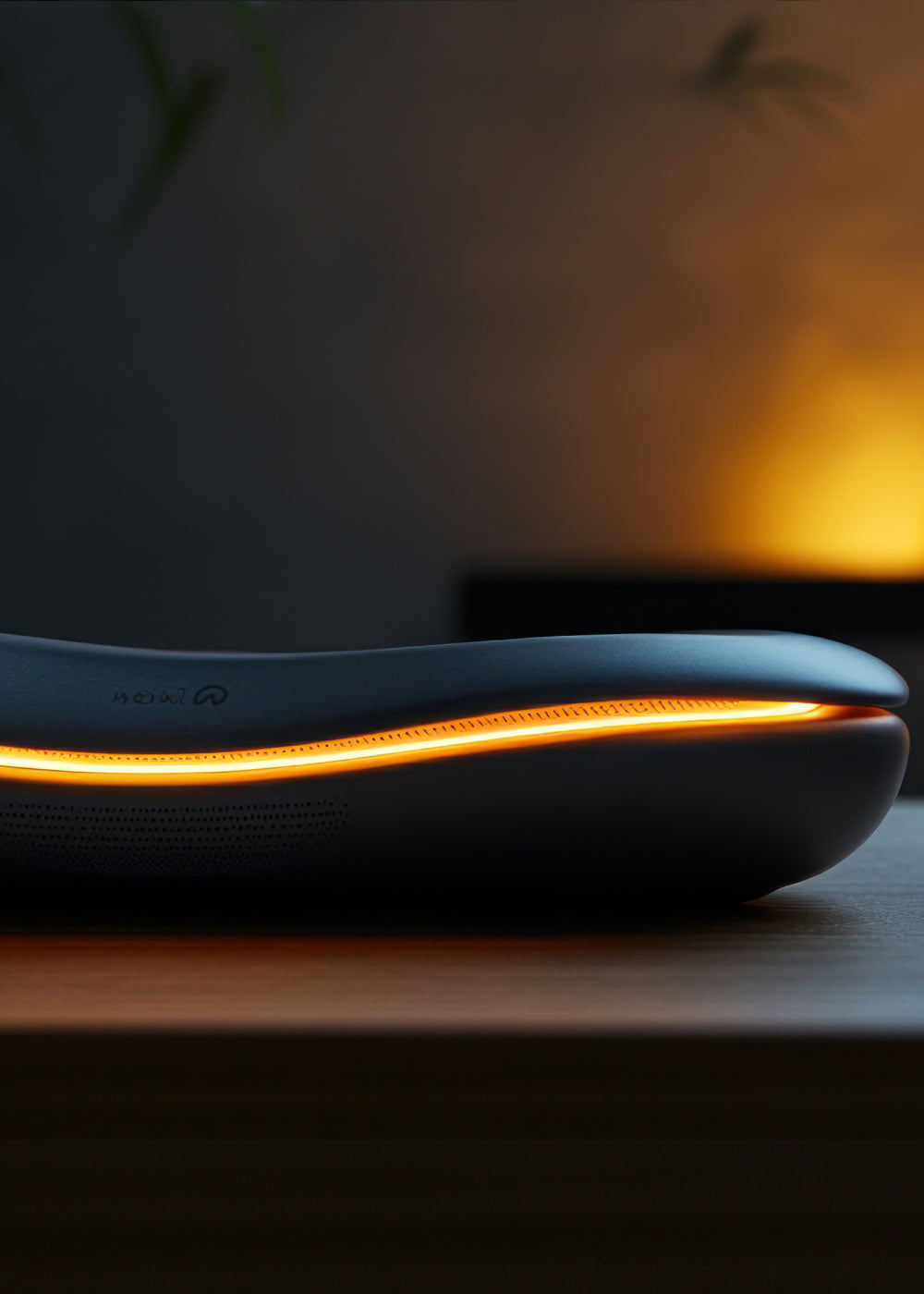 Black electronic device with glowing orange light on a dark surface