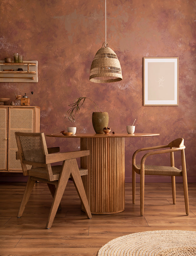 Dining area with wooden table and chairs against a textured brown wall.